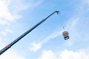 Zement oder Beton Eimer hängend auf Draht beim Konstruktion Seite? ˅ mit Blau Himmel Hintergrund foto