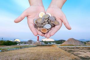 Münzen im Hände auf Industrie Landschaft Hintergrund, Spende Investition Fonds finanziell Unterstützung Nächstenliebe Dividende Markt reich geben geplant Buchhaltung Sammlung Schuld foto