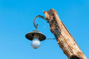 alt Lampe auf Post Holz auf blauer Himmel foto