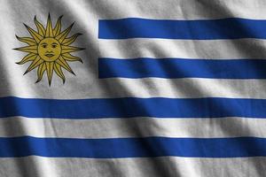 uruguay-flagge mit großen falten, die nah oben unter dem studiolicht drinnen winken. die offiziellen symbole und farben im banner foto