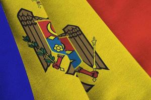 moldawische flagge mit großen falten, die im innenbereich unter dem studiolicht wehen. die offiziellen symbole und farben im banner foto