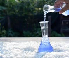 Wissenschaftler ist Gießen ein Blau Lösung von ein Wissenschaft Flasche in ein Tube Prüfung im das modern Labor Zimmer. das Bildung Chemie und medizinisch Wissenschaft Forschung Konzept. foto