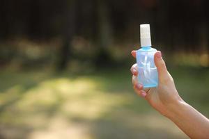 Frauenhand, die Alkoholspray oder Anti-Bakterien-Spray im Freien hält, um die Ausbreitung von Keimen, Bakterien und Viren zu verhindern, Quarantänezeit, Fokus auf Nahaufnahmen. Coronavirus. Platz kopieren. selektiver Fokus foto