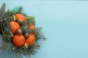 Weihnachten Strauß von Tanne Geäst, Mandarinen und wenig Geschenk Kisten auf Blau Hintergrund. Neu Jahr. selektiv Fokus. foto