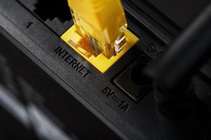 kabellos Modem Router mit Gelb Kabel und lan Hafen zum Verbindung auf ein schwarz Hintergrund. foto