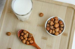 auf ein hölzern Tafel Haselnuss Nüsse und ein Glas von Milch, das Konzept von Milch von Nüsse foto