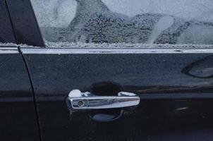 das Griff von das Auto Tür erstarrte im das Winter auf das Straße foto