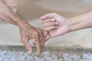 Nahansicht von alt und jung Haken jeder Andere wenig Finger, Tochter Frau unterstützen reifen Mama, zeigen Pflege, und Liebe. Unterstützung zum das Alten und zusammen Konzept. foto