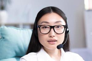 Nahansicht Porträt von ein jung schön asiatisch Frau mit Brille lächelnd und suchen beim das Kamera foto