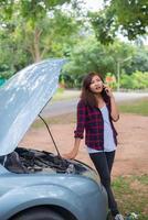 junge Frau mit einem kaputten Auto foto