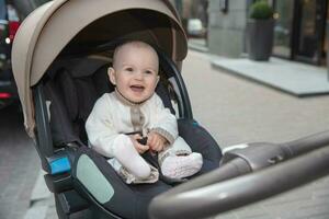 Lächeln wenig Baby Sitzung im ein Kinderwagen foto