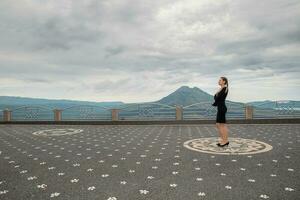 nett Frau tragen im schwarz Kleid gegen das Hintergrund von das Vulkan batur foto