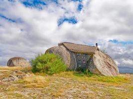 Felsbrocken Haus oder casa tun penedo, ein Haus gebaut zwischen enorm Felsen auf oben von ein Berg im fafe, Portugal. in der Regel berücksichtigt einer von das am seltsamsten Häuser im das Welt. foto