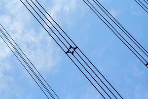 Hochspannung und isoliert Kabel suspendiert im das Blau Himmel sind Kabel Das tragen Elektrizität und Elektrizität zum Menschen und viele industriell Pflanzen und Unternehmen Das brauchen Elektrizität. foto