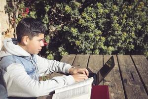 jung Latino Mann studieren, draußen, mit ein Laptop, Schreiben, Schreiben, Schreiben foto