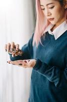 Depression einer Frau, die eine Flasche mit Pillen in der Hand hält, um die verschriebenen Medikamente einzunehmen foto