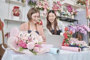 Zwei junge, schöne Floristenpartnerinnen diskutieren Flora-Bündeldekoration, Online-Bestellungen und Website-Arrangements für Unternehmen, glückliche Arbeit in farbenfrohen Blumengeschäften und E-Commerce-KMU. foto