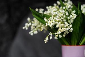 Weiß Lilie von das Senke Blumen Stand im ein Vase mit Grün Blätter und Tau Tropfen foto