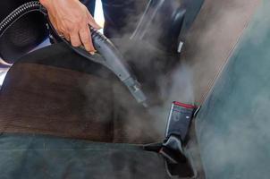 Verwenden von Dampf mit hoher Hitze, um Keime abzutöten und Autositze zu reinigen foto