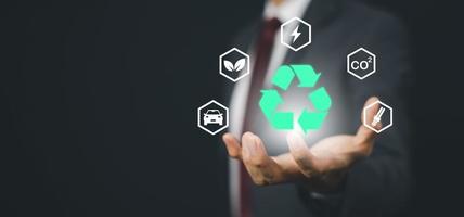 Geschäftsmann Hand halten Recycling-Symbol Verbindung mit virtuellem modernem CO2-Emissionskonzept mit Symbolen reduzieren, CO2-Fußabdruck Klimawandel zur Begrenzung der globalen Erwärmung, Energie foto