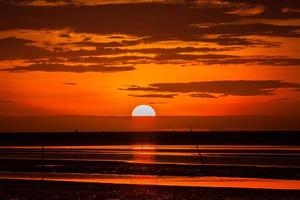 roter Sonnenuntergang am Strand foto