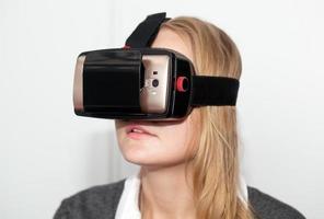 Frau, die vr-Headset auf weißem Hintergrund trägt foto