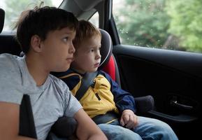 Jungen schauen aus einem Autofenster foto