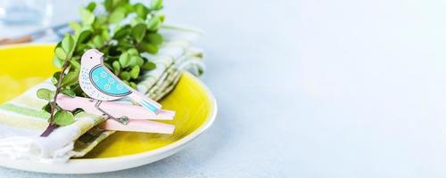 festliche Tischdekoration für Feiertags-Osteressen auf hellem Betontisch. frühlingsferienkartenkonzept foto