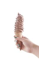 Frau Hand halten Schokolade Eis Sahne im ein Kegel isoliert auf Weiß hintergrund.eis Sahne im Waffel Kegel foto