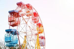 Riesenradspieler der lustigen Kinder mit blauem Himmel, altem und altem Riesenrad foto