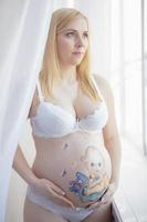 nett schwanger Frau mit ein charmant Zeichnung auf ihr Bauch foto