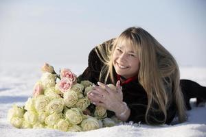 glücklich mittleren Alters Frau auf ein Winter Tag mit ein Strauß von Rosen. foto