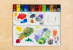 Metall Aquarell Palette Box mit bunt Aquarell einstellen auf Holz Hintergrund. foto