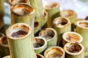 thailändisch Nachtisch. gemacht durch verbrannt klebrig Reis mit Süss Kokosnuss Milch und stellen gedämpft Ginkgo Nuss oder gedämpft Taro auf oben im Bambus Gelenke. foto