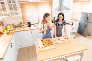 zwei kaukasisch Frauen Kochen Pizza zusammen im das Küche. das Konzept von hausgemacht Essen und lgbt Beziehungen. Familie und Vielfalt Konzept. lgbt. foto