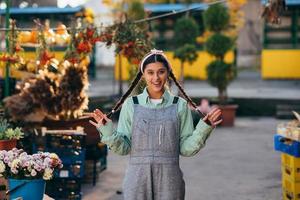 Verspielte Bäuerin in Denim-Overalls, die aufrichtig lächelt, während sie posiert. foto