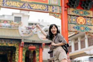 jung asiatisch Frau Rucksack Reisender genießen China Stadt, Dorf Straße Essen Markt im Bangkok, Thailand. Reisender Überprüfung aus Seite Straßen. foto