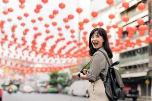 jung asiatisch Frau Rucksack Reisender genießen China Stadt, Dorf Straße Essen Markt im Bangkok, Thailand. Reisender Überprüfung aus Seite Straßen. foto