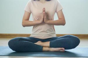 Frau Sitzung im Lotus Position abspielen Yoga im das Zimmer ruhig und entspannt. foto