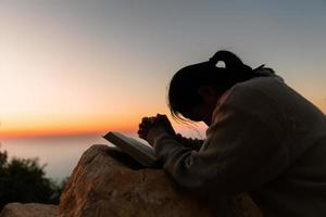 Silhouette von Frau kniend Nieder beten zum Anbetung Gott beim Himmel Hintergrund. Christen beten zu Jesus Christus zum Ruhe. im Morgen Menschen habe zu ein ruhig Platz und betete. Kopieren Raum. foto