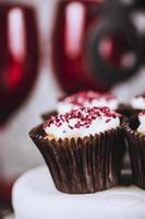 rot Samt Cupcakes auf Hochzeit Kuchen mit rot Wein Brille im Hintergrund foto