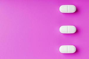 Weiß Ekstase Tabletten im ein Reihe auf ein Rosa Hintergrund, isolieren. foto
