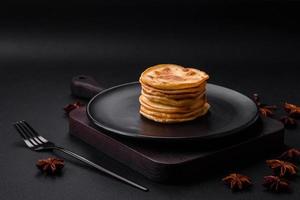 köstlich frisch Pfannkuchen mit Beere Marmelade auf ein schwarz Keramik Teller foto