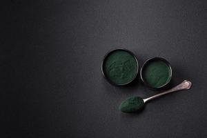 würzen, Grün Farbe Spirulina im das bilden von Pulver im ein schwarz Schüssel foto