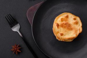 köstlich frisch Pfannkuchen mit Beere Marmelade auf ein schwarz Keramik Teller foto