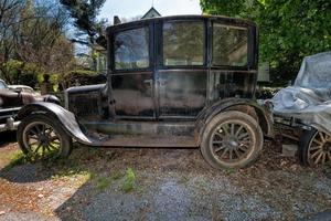 Altes, verlassenes, verrostetes Auto auf einem Feld foto