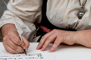 Hände schreiben einen Brief mit einer Feder foto