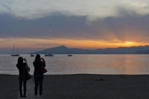 mann und frau küssen sich am strand von sestri levante bei sonnenuntergang foto