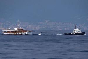 Schlepper, der ein kleines Bootsschiff schleppt foto