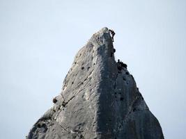 Kletterer auf Goloritze-Felswand am Meer Sardinien Italien foto